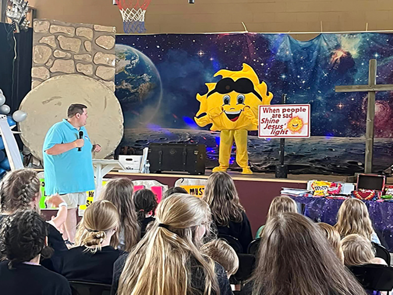 Man talking with Sun Mascot at Camp